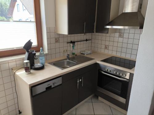 a small kitchen with a sink and a stove at Ferienwohnung Bermbach in Weilburg