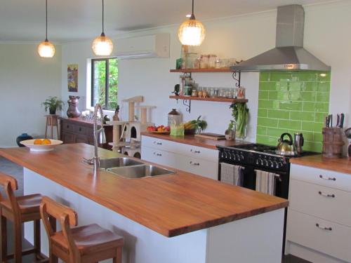 a kitchen with a wooden counter top and a sink at Rolling Hills Country Stay B&B in Tauranga