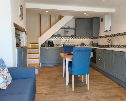 a kitchen with blue cabinets and a table and chairs at Dartmouth Diddy House in Dartmouth