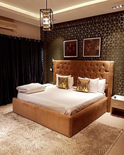 a bedroom with a large bed in a room at Posh Hotelia in Hausa