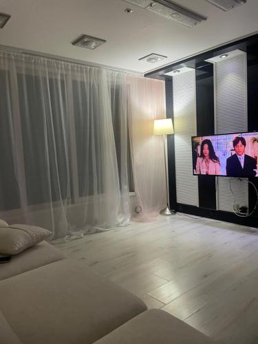 a living room with a flat screen tv and a bed at 외국인여성전용게스트하우스 in Pup'yŏng-yŏk