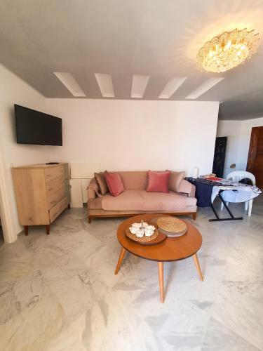 a living room with a couch and a table at Comfortable Apartment with Sea View – Hergla – 75 m² in Harqalah