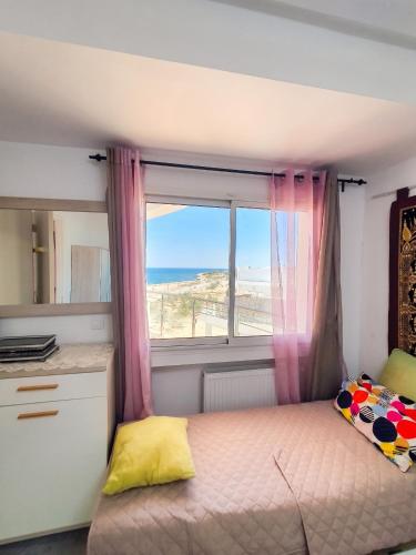 a bedroom with a bed and a window with the ocean at Comfortable Apartment with Sea View – Hergla – 75 m² in Harqalah