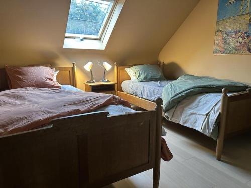 a bedroom with two beds and a window at Hooiland's Hof in Diest