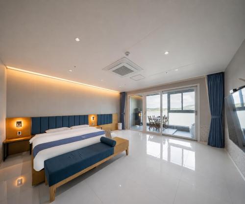 a bedroom with a large bed and a large window at Hotel Opus in Gyeongju