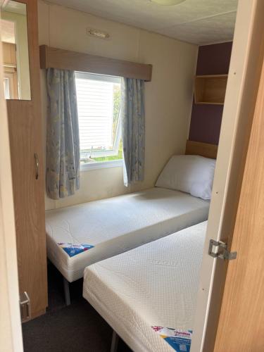a small room with two beds and a window at 159 cambersands in Hastings