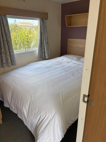 a bedroom with a white bed and a window at 159 cambersands in Hastings