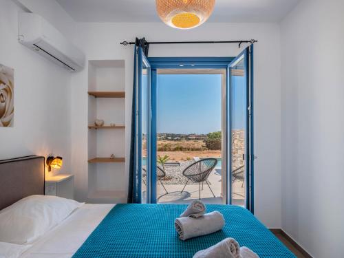 a bedroom with a bed and a glass door leading to a patio at Cycladic home in Paros in Kampos Paros
