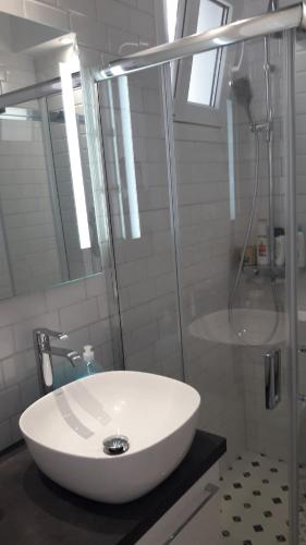 a bathroom with a white sink and a shower at Veranda Agia Marina in Agia Marina Aegina