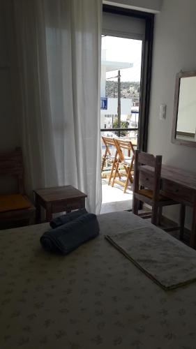 a bedroom with a bed and a window and a table at Veranda Agia Marina in Agia Marina Aegina