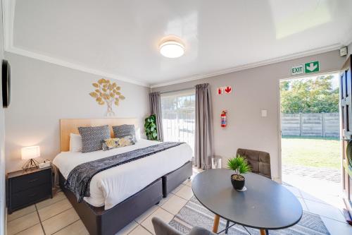 a bedroom with a large bed and a table at 16 Vaalrivier in Secunda