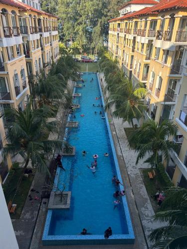 an overhead view of a large swimming pool with people in it at Tiara Homestay Desaru - Garden Pool View in Bandar Penawar
