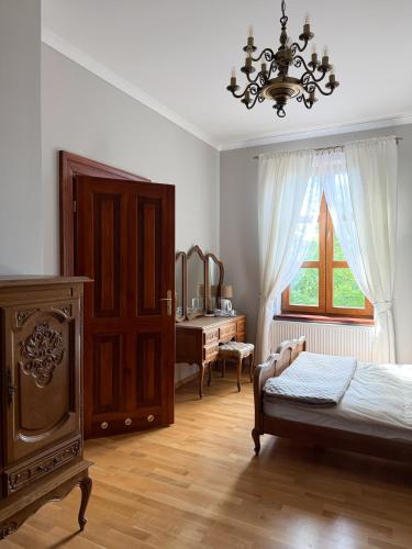 a bedroom with a bed and a dresser and a window at Modrzewiowy Dworek in Mirzec
