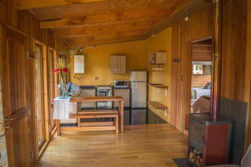 una cocina con mesa en una casa pequeña en Los Lingues Lodge, en Puerto Octay
