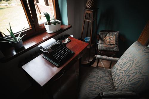a desk with a keyboard and a chair and a window at Agroturystyka Czułe Miejsce in Zdory