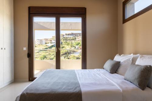 a bedroom with a large bed with a large window at Villa Mononaftis in Agia Pelagia