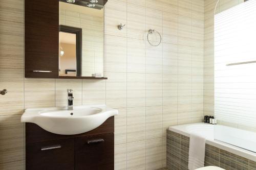 a bathroom with a sink and a toilet and a tub at Villa Mononaftis in Agia Pelagia