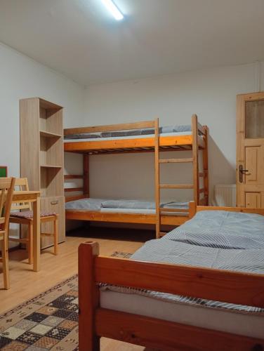 a bedroom with two bunk beds and a table at Chalupa Mlyn Dolný Kubín in Dolný Kubín