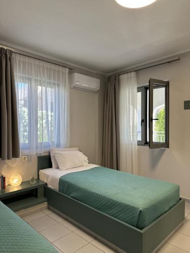 a bedroom with two beds and a window at Evdokia Suites in Gouves