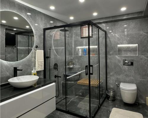 a bathroom with a glass shower and a sink at 2 bedrooms living apartments in Lahore