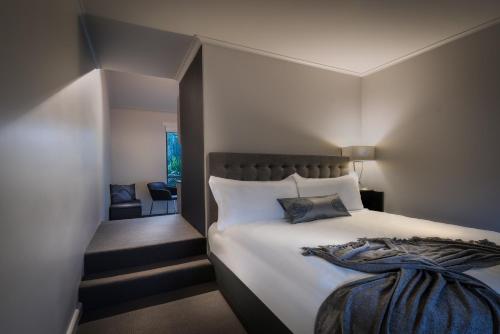 a bedroom with a large bed and a staircase at Crest on Park in Melbourne