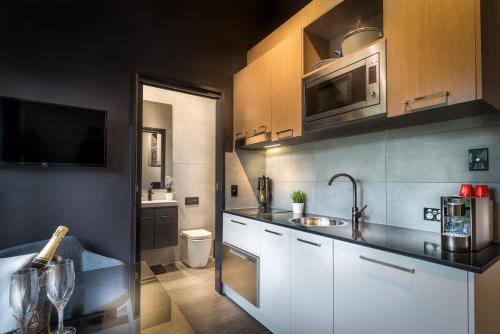 a kitchen with white cabinets and a sink at Crest on Park in Melbourne