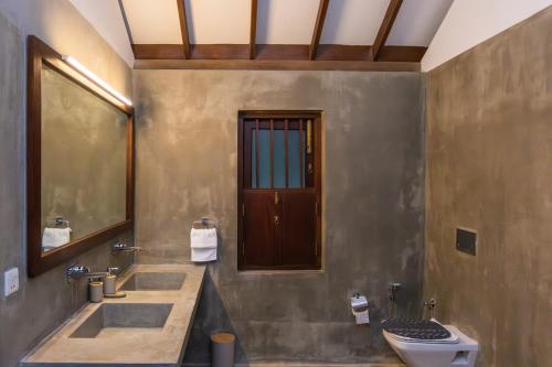 a bathroom with two sinks and a toilet at Tropical Grove in Polgolla