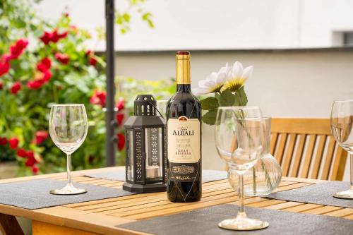 Eine Flasche Wein steht mit Weingläsern auf einem Tisch. in der Unterkunft MOLA Apartments-Stilvolle Altstadtwohnung- Seilersee-5 Personen-Terrasse-Grill-Gratis WLAN in Iserlohn