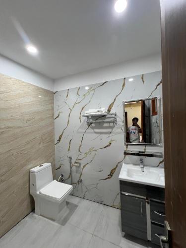 a bathroom with a toilet and a sink and a mirror at Oasis hotels in Hoshiārpur