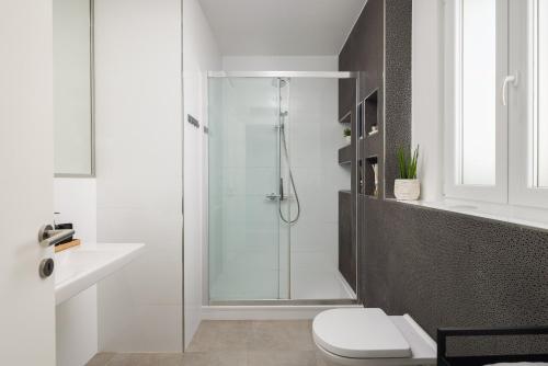 a white bathroom with a shower and a toilet at Villa Lavanda Deluxe in Rogoznica