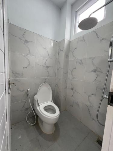 a bathroom with a toilet and a window at hb co living in Tanjungredep