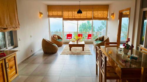 a living room with a table and chairs at Granny's Den - Nathia Gali in Nathia Gali