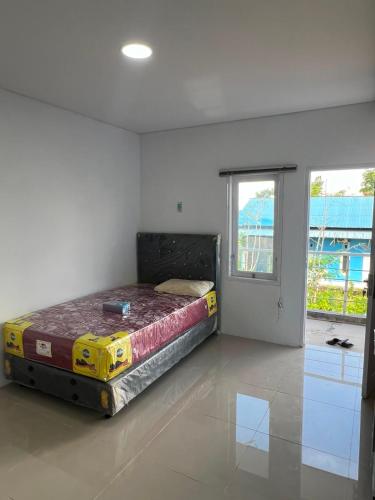 a bedroom with a bed in a room with a window at hb co living in Tanjungredep