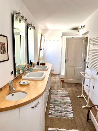 a bathroom with two sinks and two mirrors at Giué in Bovalino Marina