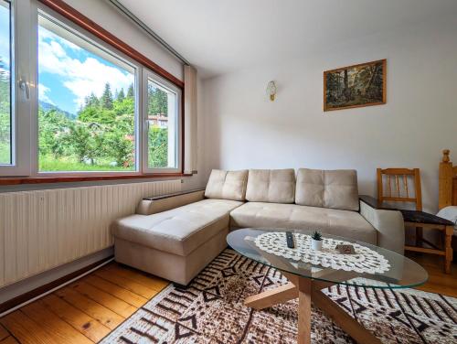 a living room with a couch and a glass table at Апартамент Извор 6 in Smolyan
