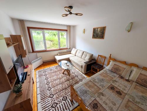 a living room with a bed and a couch at Апартамент Извор 6 in Smolyan
