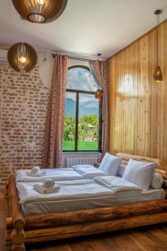 a bedroom with a large bed with a window at Hotel Piano Kvareli in Kvareli