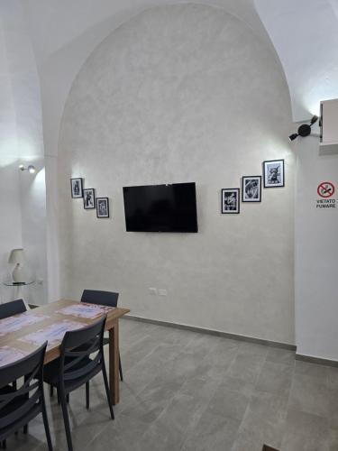 a dining room with a table and a television on a wall at Casa Vacanza S Elia in Veglie