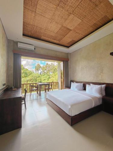 a bedroom with a large bed and a balcony at Nawang Sakti in Ubud