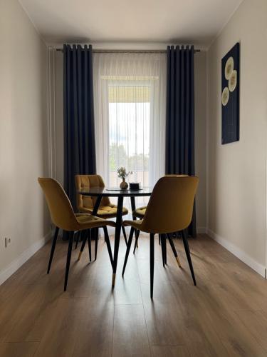 a dining room with a table and chairs and a window at Golden corner in Plungė