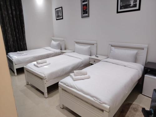 a room with three beds and a couch at KA Hôtel Dely Ibrahim in Deli Ibrahim