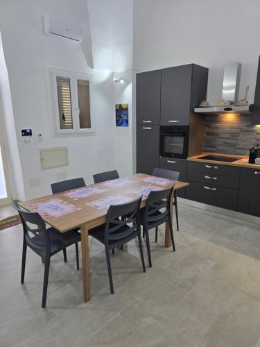 a kitchen with a wooden table and chairs in a room at Casa Vacanza S Elia in Veglie
