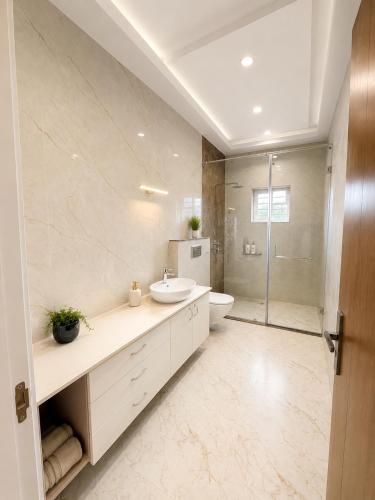 a white bathroom with a sink and a shower at Private Farm with Big Size Pool & 7 Rooms in Kukas in Jaipur