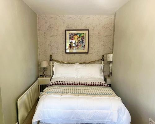 a bedroom with a bed with a picture on the wall at Dovetail Cottage in Wexford