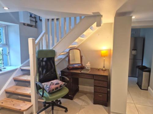 a room with a desk and a staircase with a mirror at Dovetail Cottage in Wexford