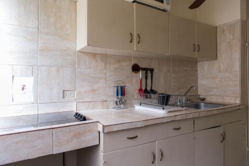 a kitchen with white cabinets and a sink at Turtle Beach Towers in Ocho Rios
