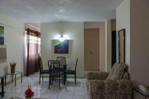 a living room with a couch and a table and chairs at Turtle Beach Towers in Ocho Rios