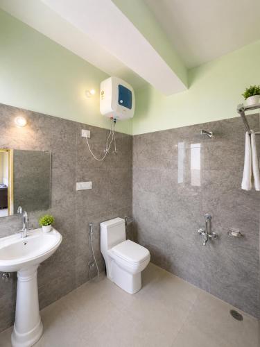 a bathroom with a toilet and a sink at Aurelia Ridge in Bīr