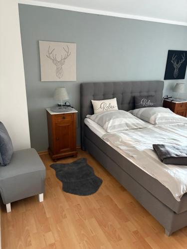 ein Schlafzimmer mit einem großen Bett und einem Stuhl in der Unterkunft Weinstraße 2 in Höchstberg