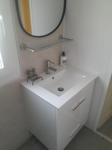 a bathroom with a white sink and a mirror at Casa da Cristina 5A in Burinhosa